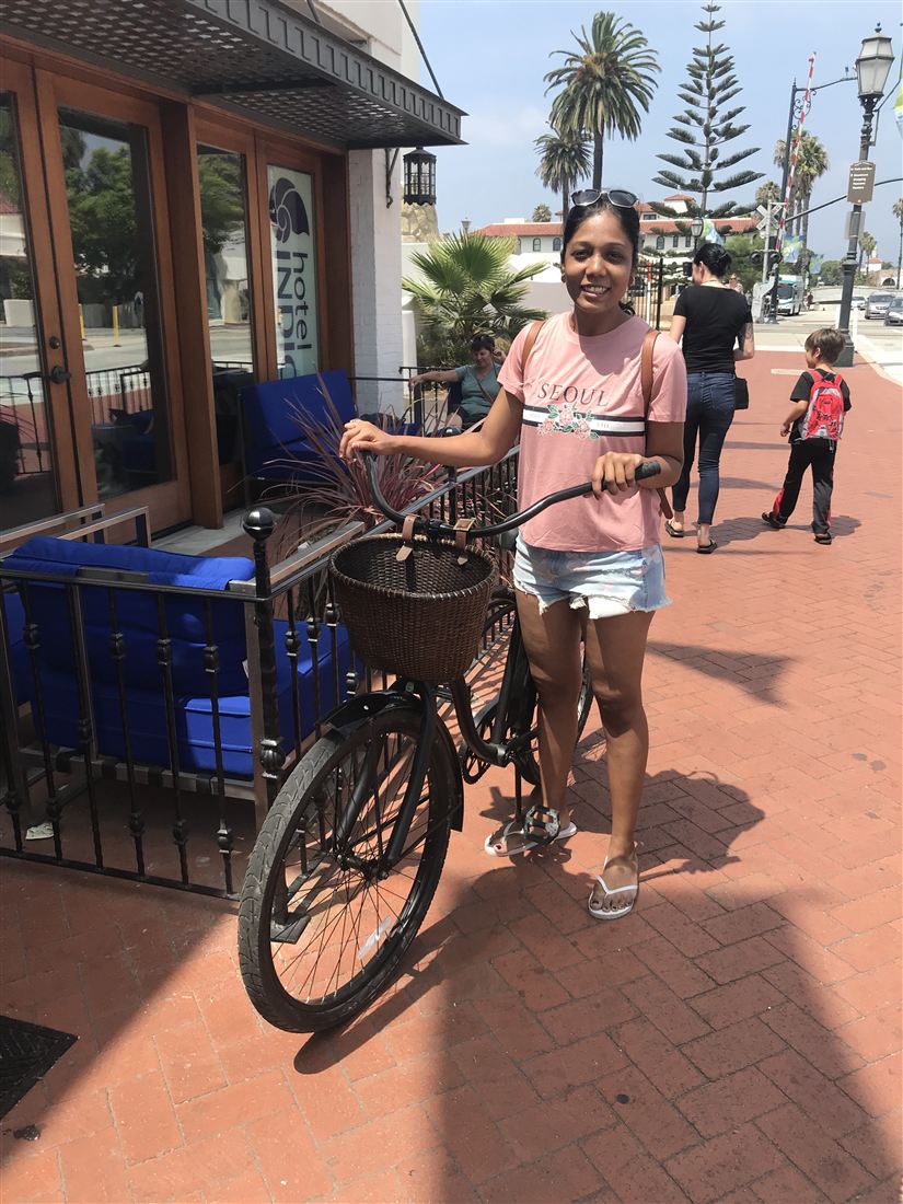 Anushree on a bicycle outside a hotel
