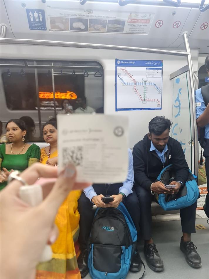 Holding a metro ticket inside a train, network map on the wall