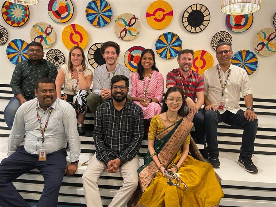 Team photo in front of a wall of woven baskets